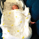Newborn baby wrapped in an Aussie Australian baby muslin swaddle yellow cockatoo 